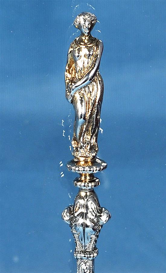 A cased set of four Victorian silver parcel gilt fruit serving spoons and a sugar sifter, spoon 197mm, weight 12.4oz/388 grms.